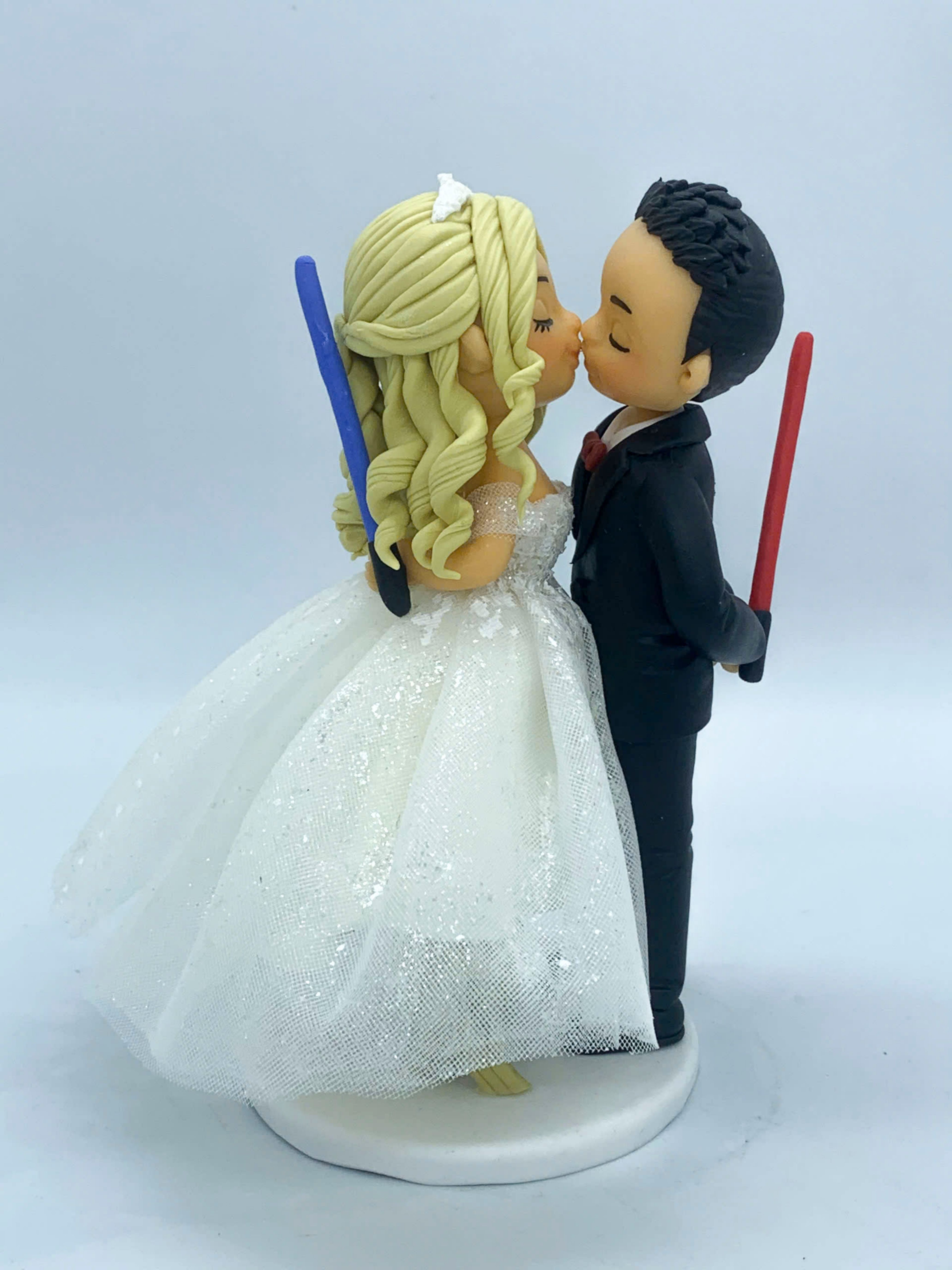 Picture of Tiny Bride & Tall Groom wedding cake topper, Bride is on Ladder kissing groom, Lightsaber Wedding Cake Topper